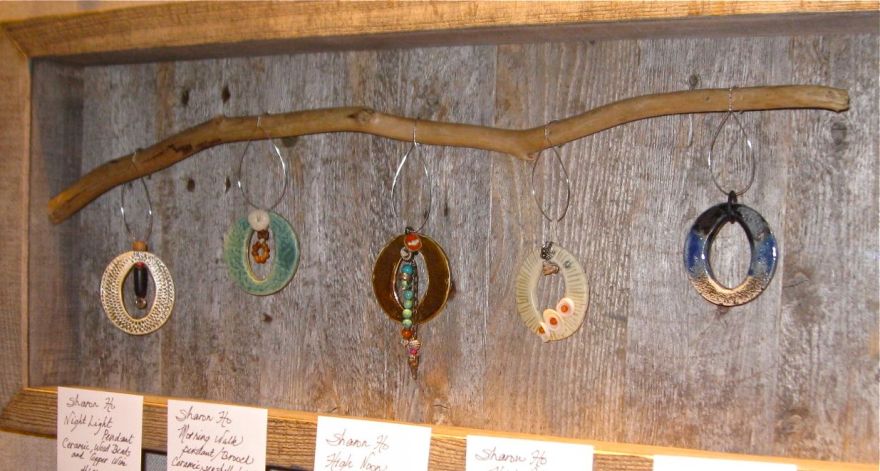 Display box of 5 ceramic pendants, embellished with seashells, found beads, jadeite stones and vintage buttons.  For individual purchase.  Prices from USD68 to USD128.